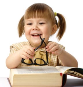 Happy little girl with huge book and glasses