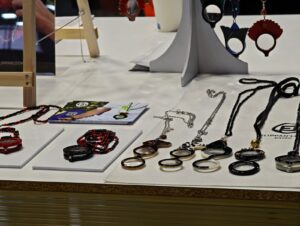 A close-up of unique eyewear accessories, including decorative chains and magnifier pendants, displayed on a table at SILMO Paris 2025.